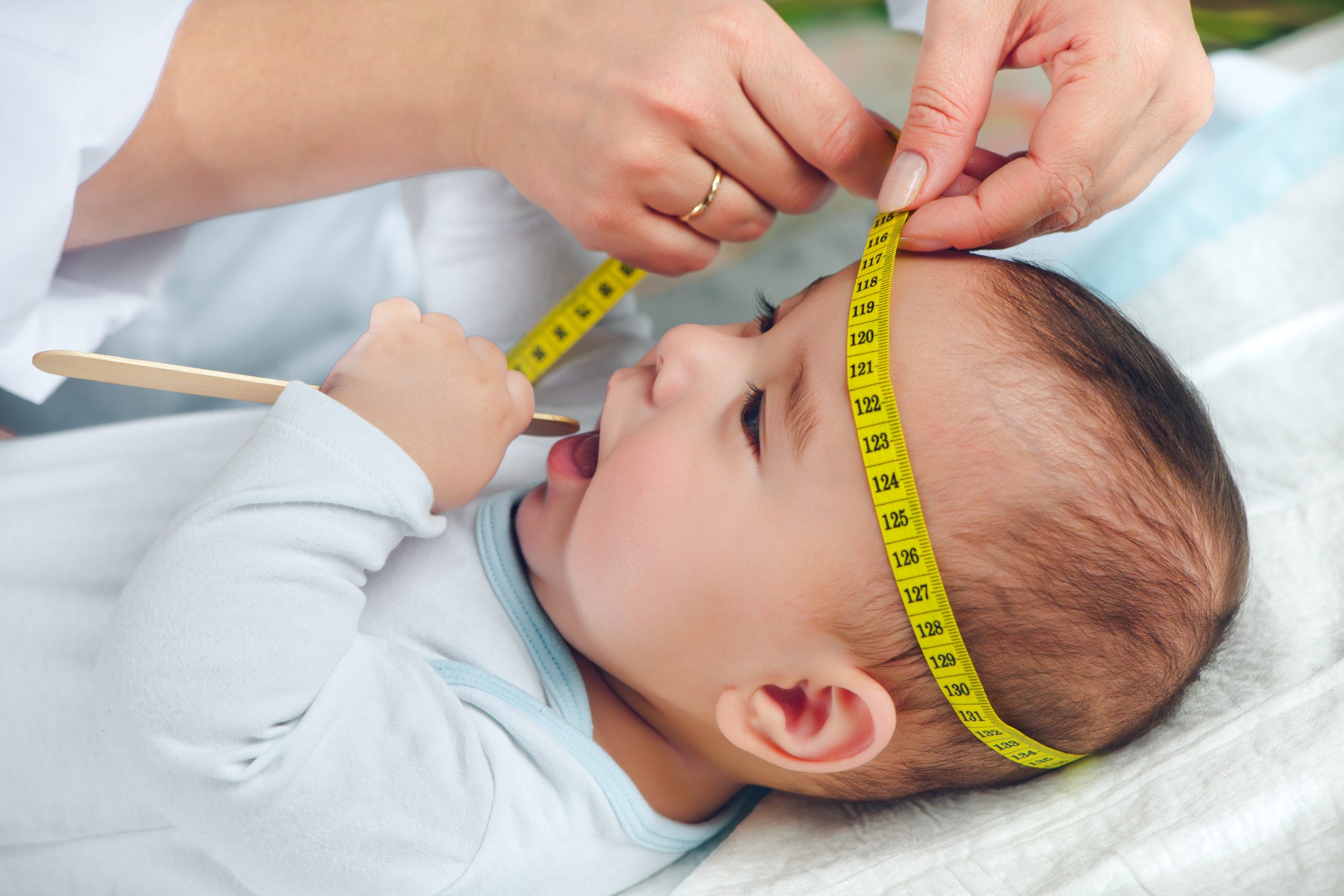 Baby bekommt den Kopfumfang gemessen